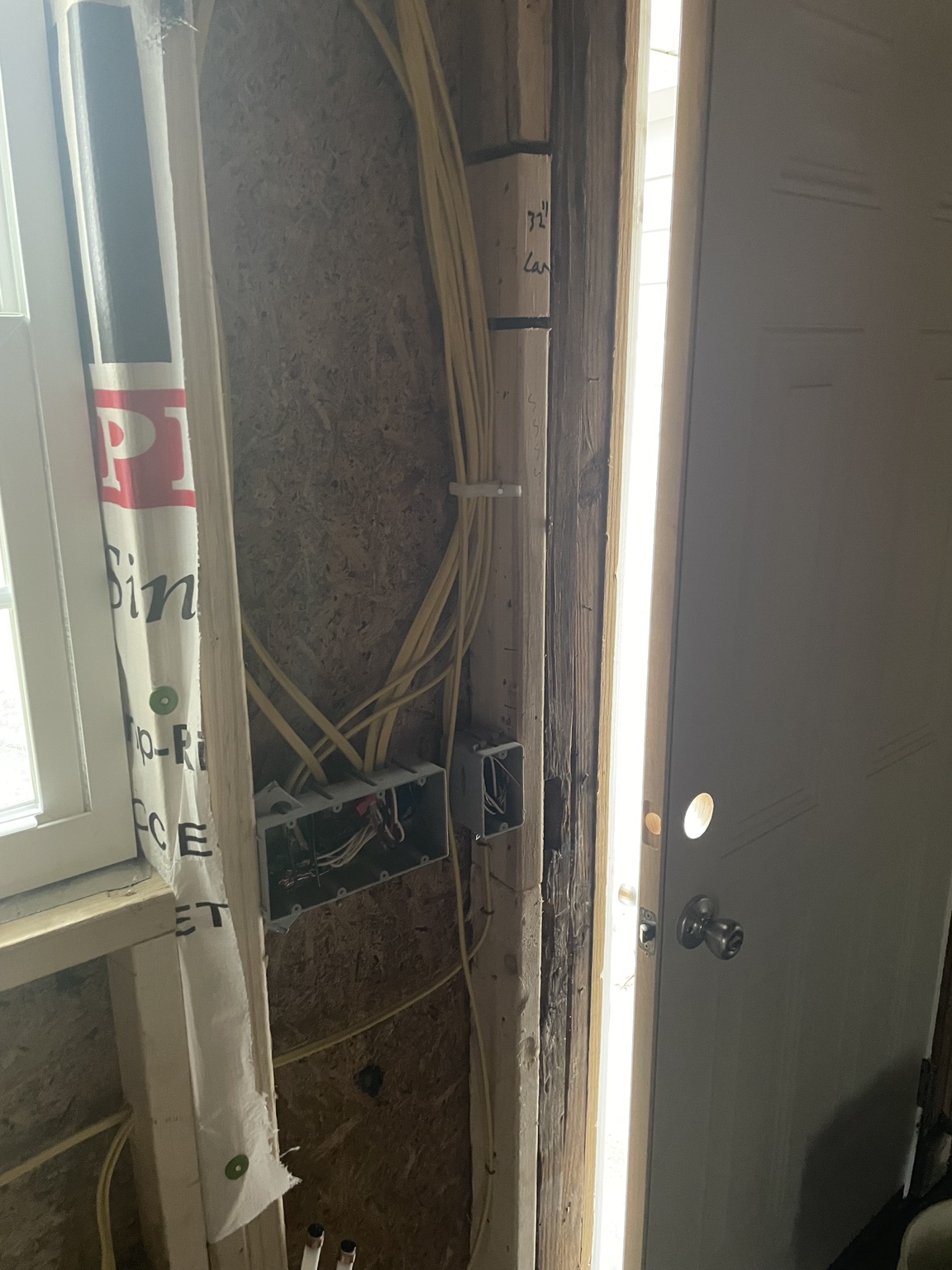 Residential wiring and electrical boxes beside doorway