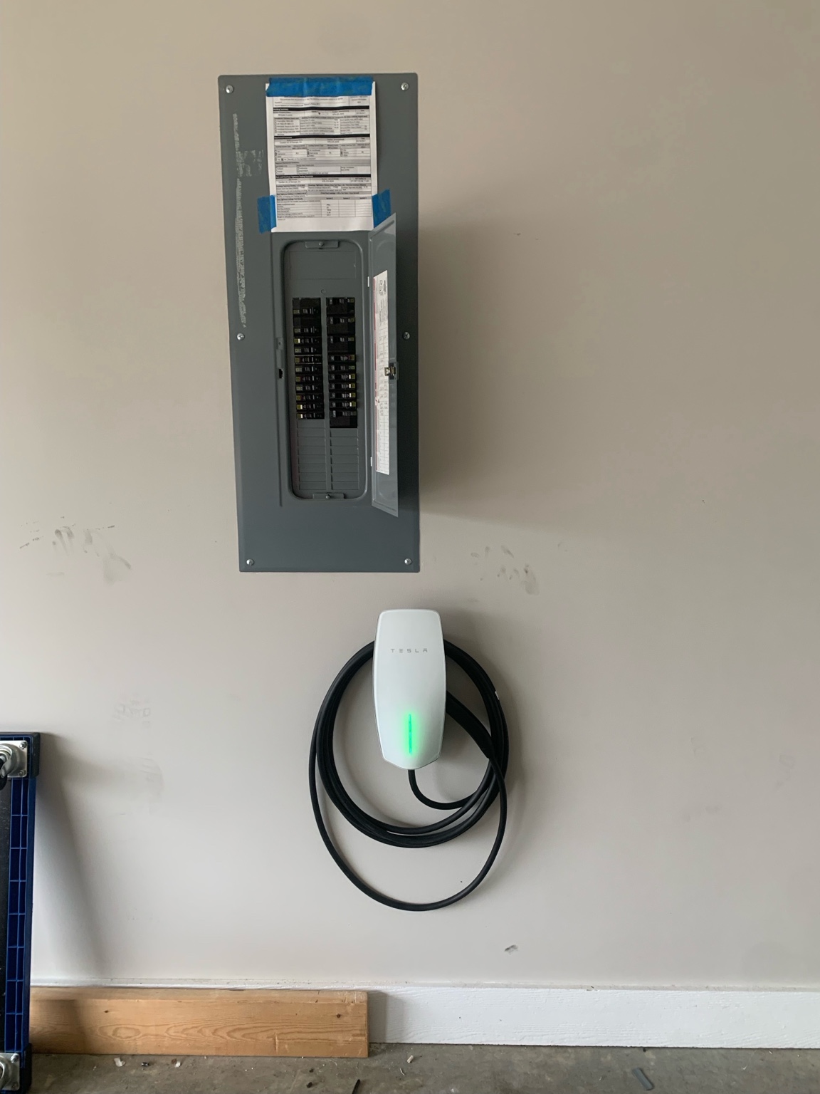 Tesla Wall Connector installed below an electrical panel