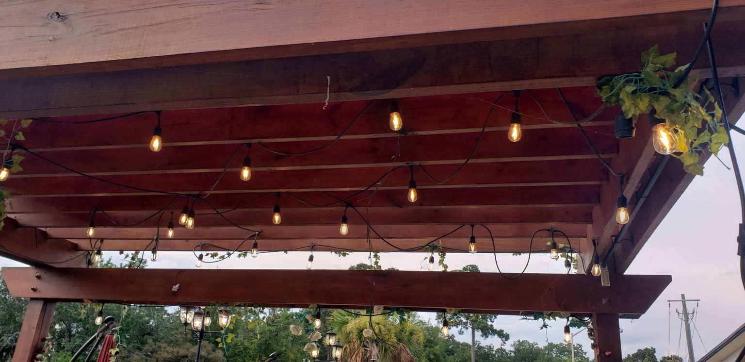 Decorative string lighting installed under outdoor structure