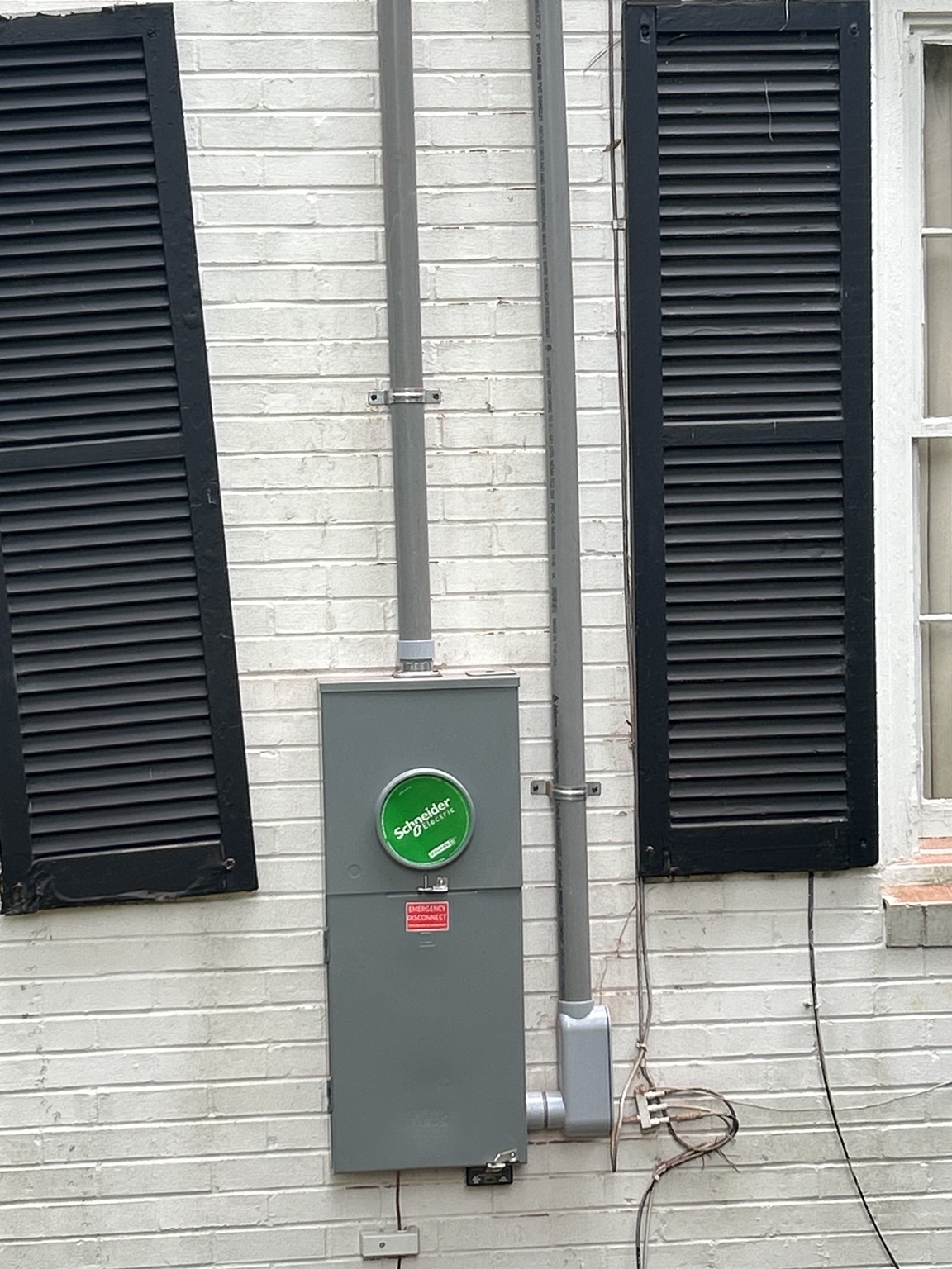 Electrical service mast and meter main installation on brick home